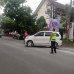 Petugas Polsek Tikung mengatur lalu lintas saat Commander Wish pagi di Simpang Tiga Pule.